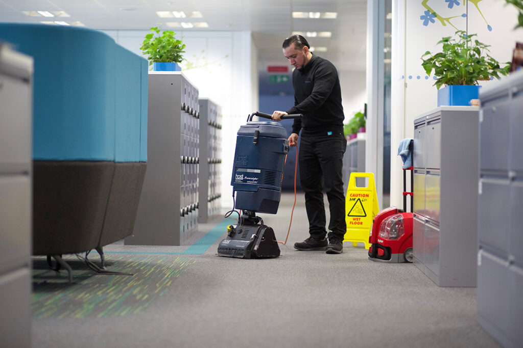 A NuServe operative using a carpet cleaning machine.