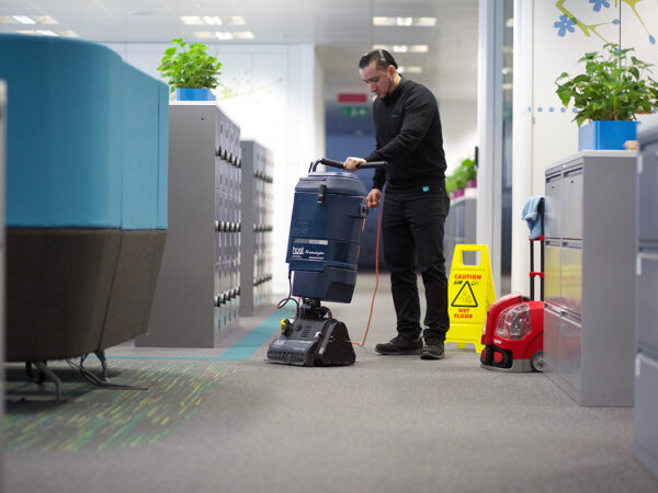 A NuServe operative using a carpet cleaning machine.