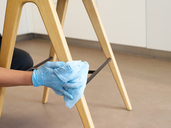 A NuServe operative wiping a chair.