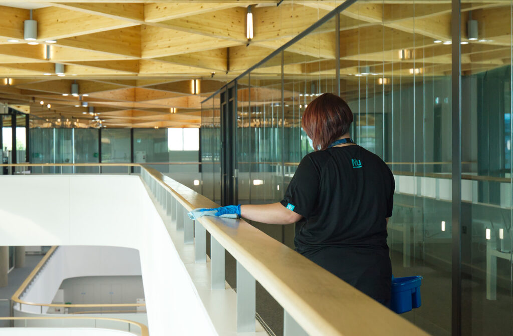 A NuServe cleaner wiping a bannister.