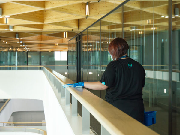 A NuServe cleaner wiping a bannister.