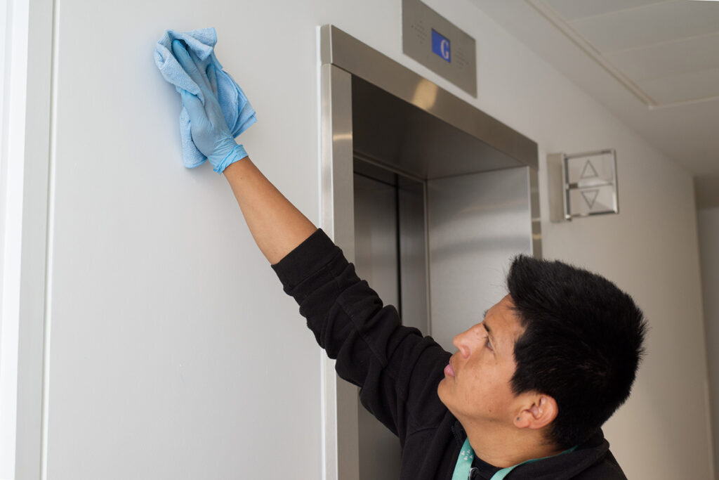 A NuServe cleaner wiping walls.