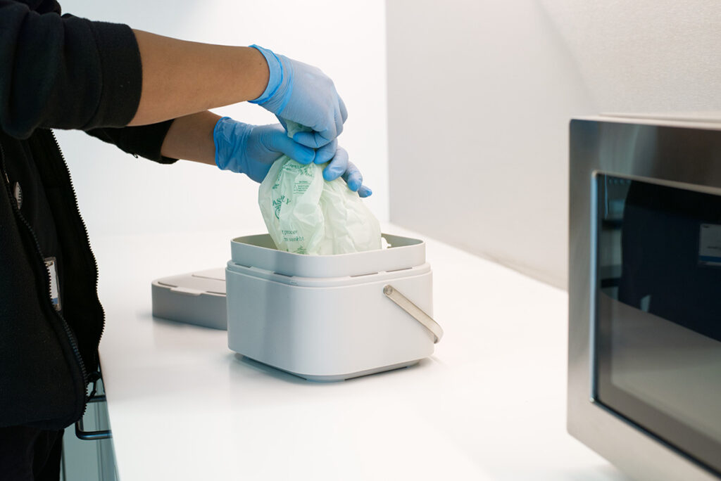 A NuServe operative changing a food waste bin.