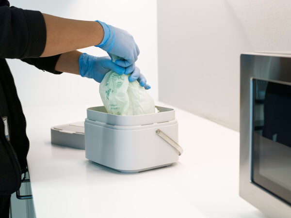 A NuServe operative changing a food waste bin.