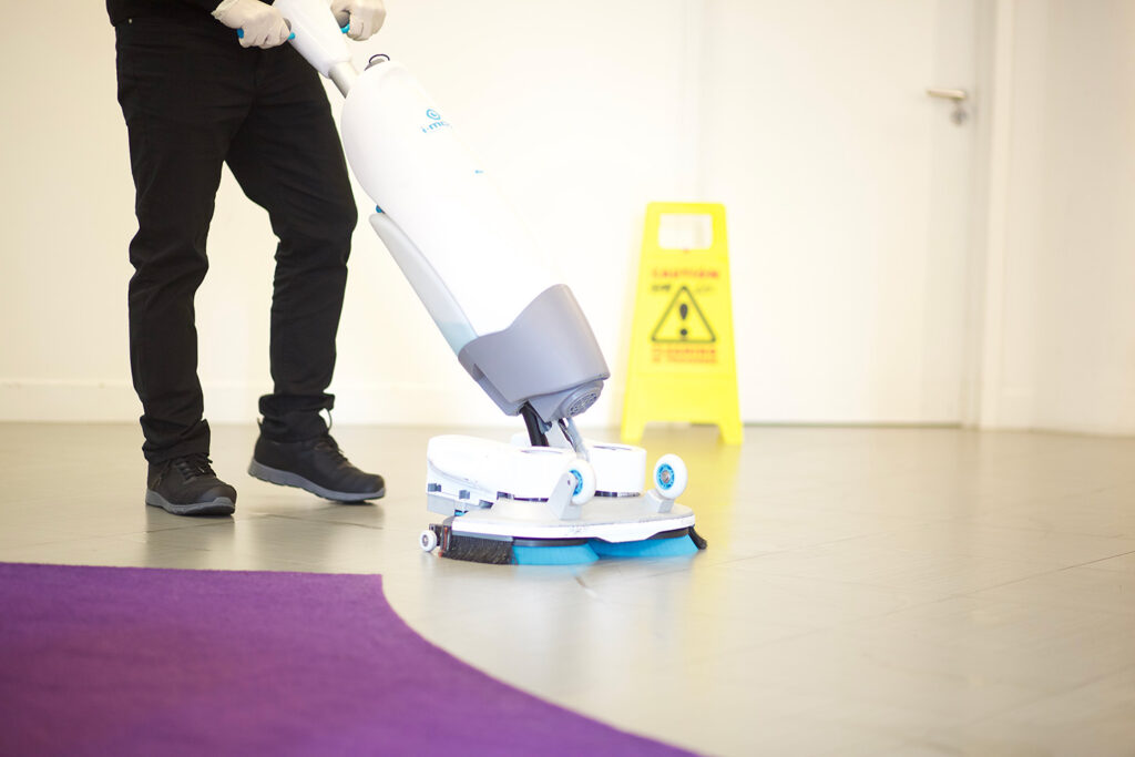 A NuServe cleaner using a floor scrubber.