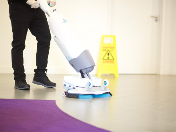 A NuServe cleaner using a floor scrubber.