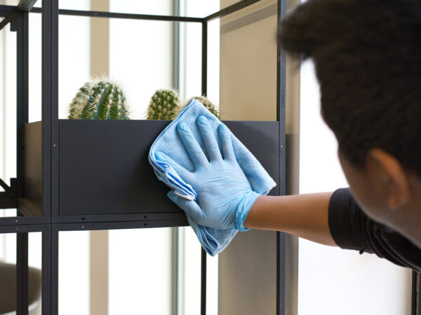 A NuServe cleaner wiping down a plant installment.