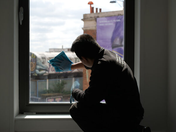 A NuServe cleaner cleaning a window.