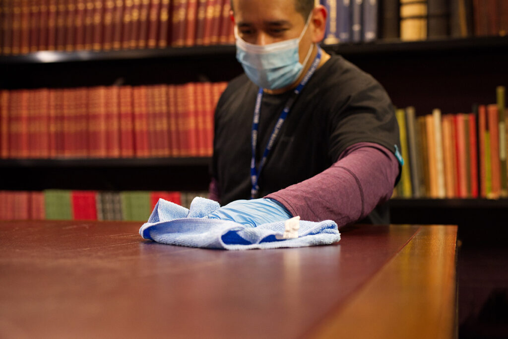 A NuServe cleaner wiping a table.