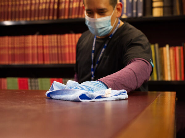 A NuServe cleaner wiping a table.