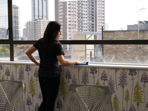 A NuServe operative cleaning a meeting room.